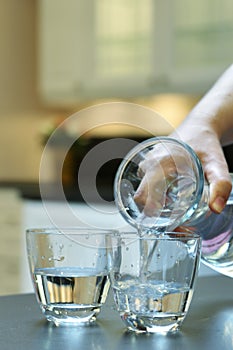 Pouring water into a glass photo