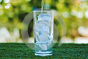 Pouring water into a glass of ice