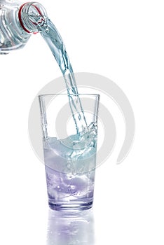 Pouring water in glass with ice cubes