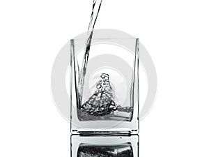 Pouring water into the glass isolated on white background.