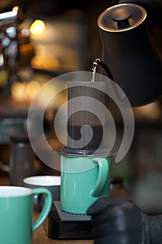 Pouring water from kettle into aeropress, coffee brewing process closeup