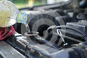 Pouring water for radiator tank in car, Overheating engine deterioration repair. photo