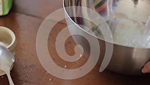 Pouring water into saucepan, close-up womans hands is cooking food