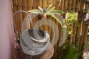 Pouring water tap, stone sink, summer garden