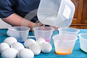 Pouring water into tubs for easter egg dyeing