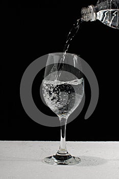 Pouring water in wineglass