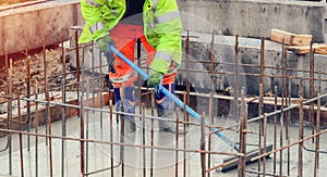 Pouring wet ready-mix concrete into lift pit base and levelling it