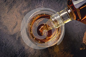 Pouring whiskey from bottle into glass on bar counter