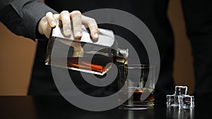 Pouring whiskey, cognac into glass. Bartender pours alcohol drink. Silhouette