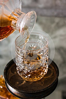 Pouring whiskey in glass. Dammed glass with strong alcoholic drink