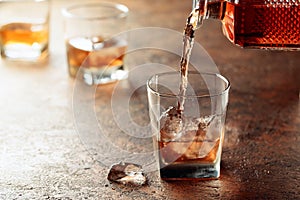 Pouring whiskey in glass with ice