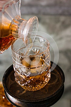 Pouring whiskey in glass with natural ice