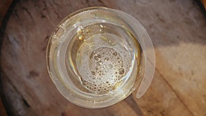 Pouring white wine into a glass, top view