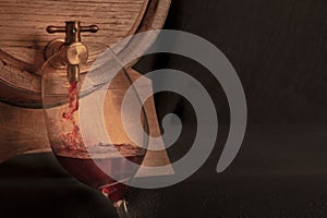 Pouring wine into a glass from an oak barrel, a panoramic close-up shot
