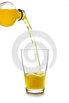 Pouring yellow softdrink lemonade made from orange juice from a