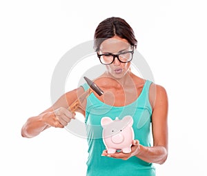 Pouting brunette woman with piggy bank