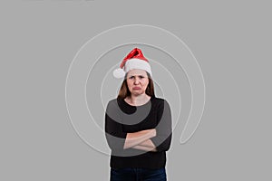 Pouting young women wearing a Christmas Santa Claus hat