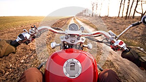 POV biking dirt road through wild autumn valley on modern red motorcycle