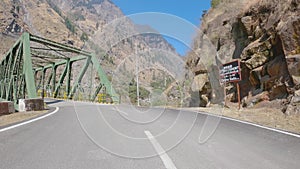 POV of car driving on road Surrounded by rocks and mountains in Uttarkashi district of Uttarakhand, India