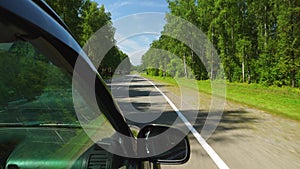 POV: Car is moving across a forest in summer day on a highway in Altay, Russia