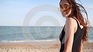 Pov follow me shot of pretty woman flirting at camera on tropical beach walking towards sea. Back view of playful