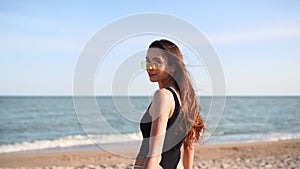 Pov follow me shot of pretty woman flirting at camera on tropical beach walking towards sea. Back view of playful