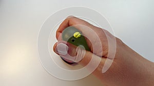 POV hand taking green jelly anti-stress toy from plastic tray. Squishy slay in shape of Japanese mochi food. Film grain