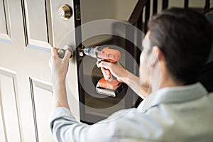 Pov of a handyman fixing door knob photo