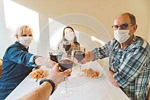 POV image of people toasting with red wine glasses during dinner