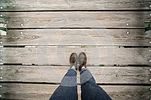 POV of leather hiking boots on wood surface