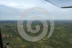 POV light aircraft across to tree covered cliffs in Kakadu National Park