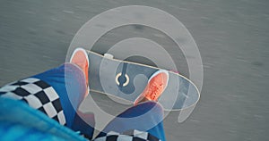 POV. Male in blue board shorts and orange sneakers ride on surf skateboard.