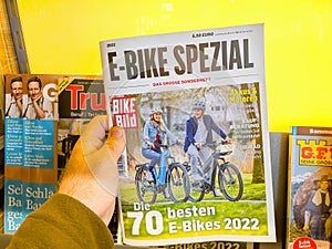 POV male hand holding new E-bike spezial german biking newspaper magazine with