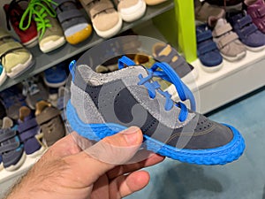 POV male hand shopping small blue children shoe