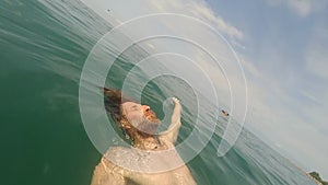 POV of man with beard swimming and in sea water on sunny day with action camera Summertime