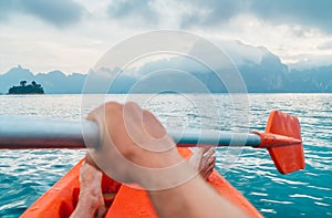 POV of Man floating in kayak holding paddle during early morning tour. Khao Sok national park, Cheow Lan lake, Thailand