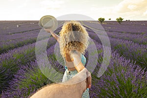 Pov of man holding woman hands with beautiful lavender field in background. Happy couple in travel lifestyle enjoying amazing