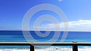 POV-Passenger side window driving scene. blue ocean against  blue sky