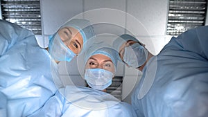 Pov patient waking up after operation anesthesia, smiling surgeon team faces