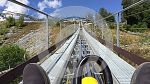 POV person riding coaster on nature in mountains in amusement park.