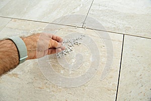 POV personal perspective worker installer holding multiple tile spacers during