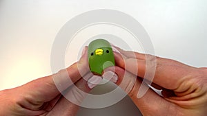 POV playing with squishy toy. Anti-stress green slime ball against white background. Eases stress. Squash funny