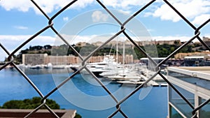 Pov of poor tourist, viewing yachts behind fence, lack of money for luxury rest