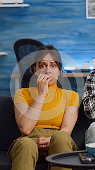 POV of shocked interracial couple watching scary movie