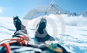 POV shoot of a high altitude mountain climber`s lags in crampons. He lying and resting on snow ice field with Ama Dablam 6812m