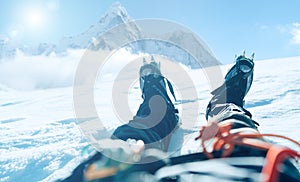 POV shoot of a high altitude mountain climber`s lags in crampons. He lying and resting on snow ice field with Ama Dablam 6812m