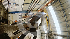 POV shot of an industrial robot lifting large metal parts during production process