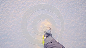 POV shot little cute child legs wearing warm shoes walking on clean smooth snow surface