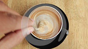 pov shot of person hand stirring coffee with spoon.