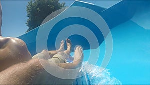 POV shot of two guys using slide in water park